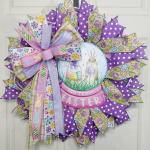 Easter wreath with dark and light purple ribbons and an easter globe sign with rabbits.